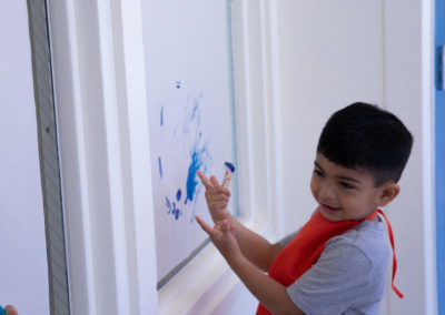 A child plays with blue paint.