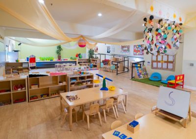 A classroom with tables, learning supplies, and fun decorations.