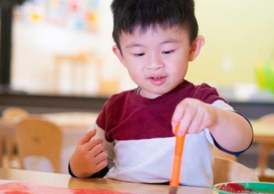 A child using a paintbrush to paint a picture.