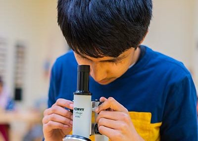 A student looking through a microscope.