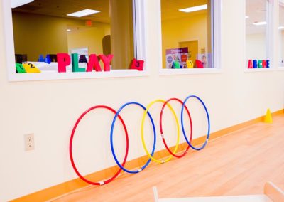 Five hoola hoops leaning up against a play room wall.