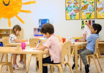 A group of toddlers drawing at a table.