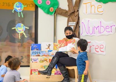 A teacher reads to a group of toddlers.