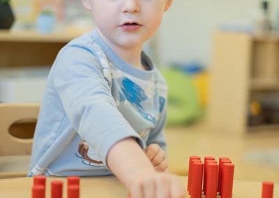 A young boy playing with wooden blocks.