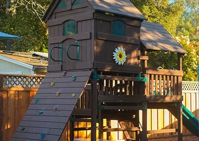 An outdoor playhouse and climbing ramp.