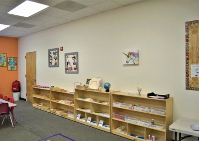 A Safari Kid classroom with wooden bookcases holding various classroom supplies.