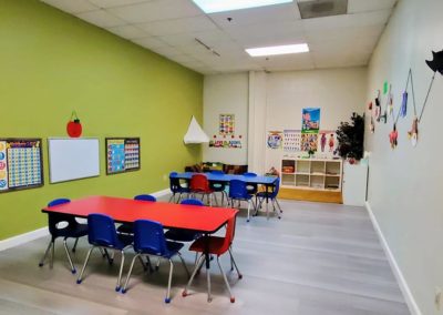 A Safari Kid classroom with two group tables and decorations hanging on the walls.